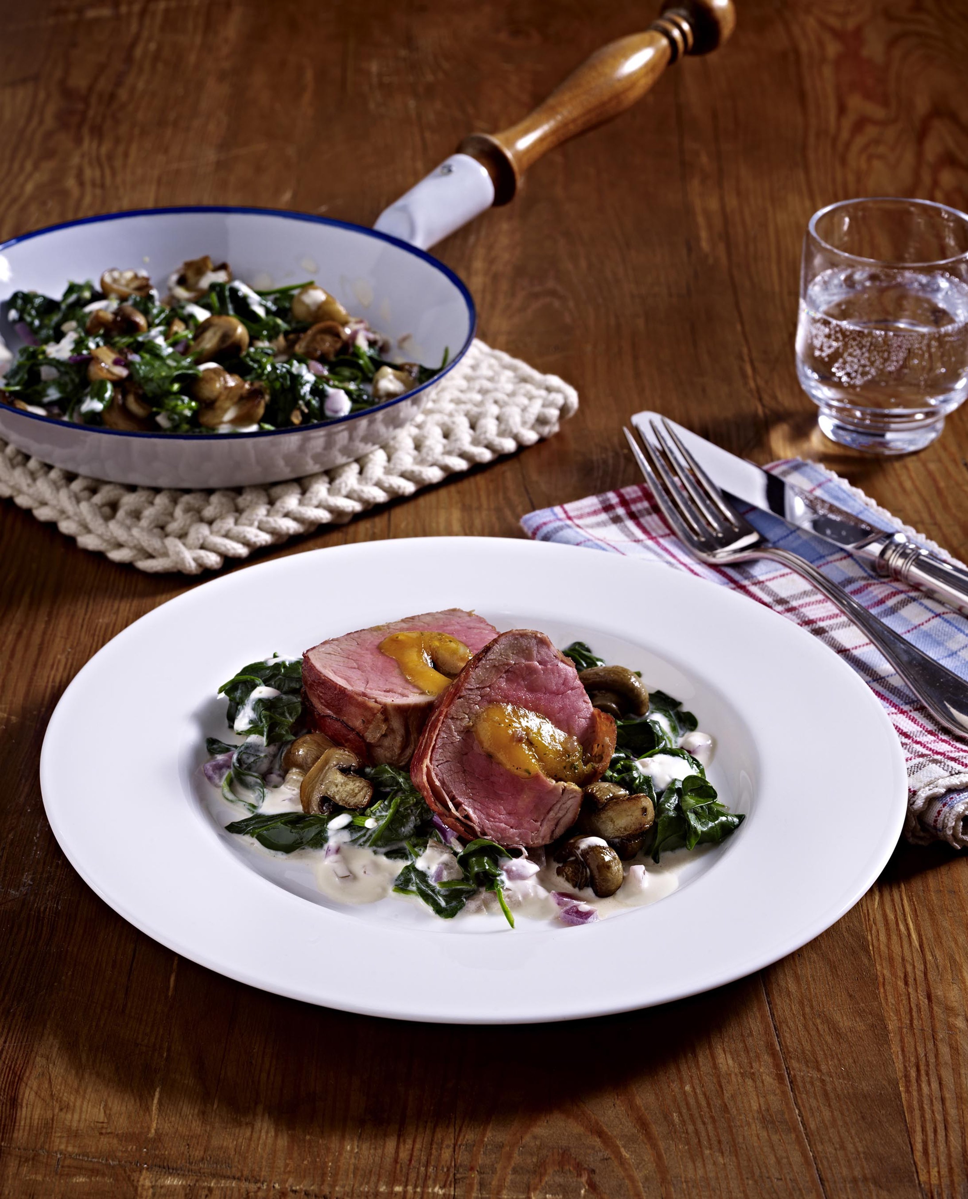 Gefuelltes_Schweinefilet_im_Parmaschinkenmantel_auf_Spinat_Champignon_Pfanne.jpg